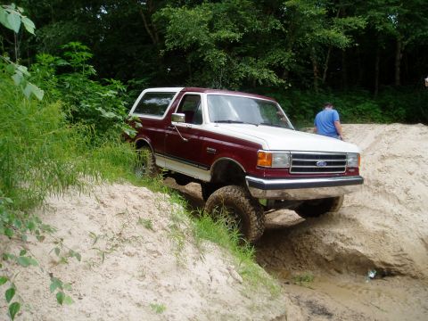 1990 Ford Bronco - This two-tone 1990 Ford Bronco navigates a challenging sandy incline during an off-road excursion.
