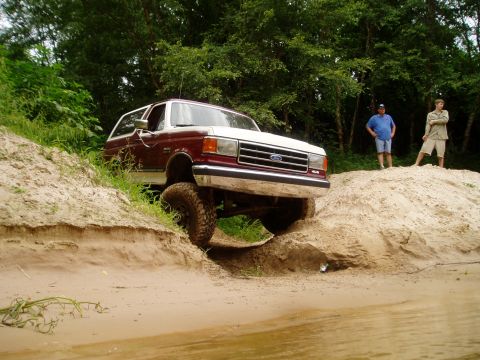 1990 Ford Bronco - Ford Bronco navigating a challenging sandy terrain.