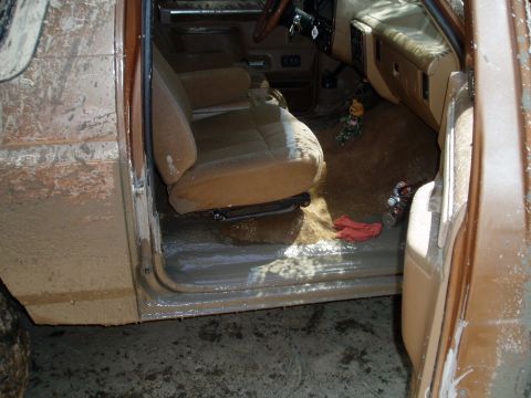 1990 Ford Bronco - The interior of a mud-covered 1987 Ford Bronco shows extensive water and dirt damage.