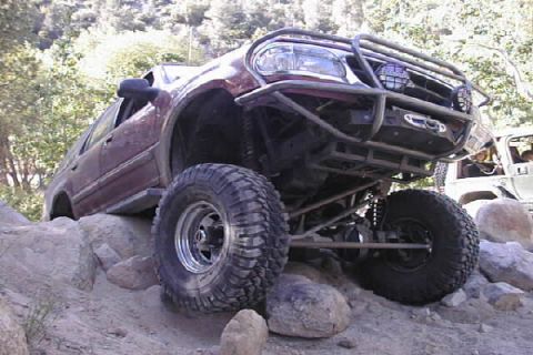 1997 Ford Ranger - A modified 1997 Ford Ranger navigates a rocky trail with another vehicle visible in the background.