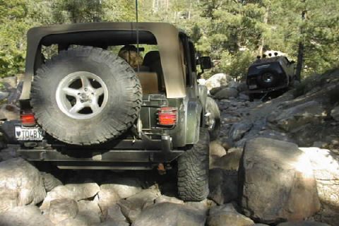 1997 Ford Ranger - Two Jeep Wranglers navigate a challenging rocky trail, with the lead vehicle showing its rear spare tire and the second vehicle further up…