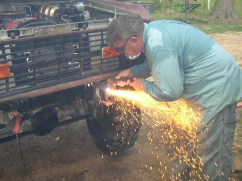 1995 Ford Bronco - A person works on the front of a 1995 Ford Bronco, creating a shower of sparks.