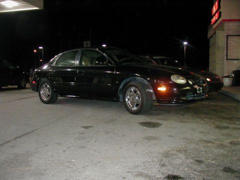 1997 Ford Taurus - Black 1997 Ford Taurus parked outside at night, with another car visible behind it.