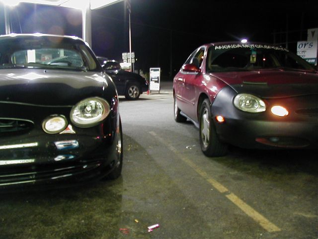 Two 1997 Ford Taurus sedans parked side-by-side at night