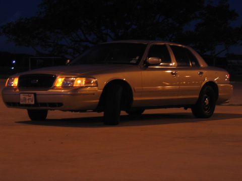 2000 Ford Crown Victoria - This gold 2000 Ford Crown Victoria is seen from a three-quarter front view at night.