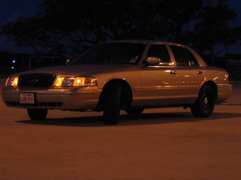 Gold 2000 Ford Crown Victoria sedan parked at night