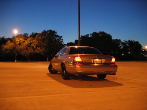 2000 Ford Crown Victoria - Rear view of a gold 2000 Ford Crown Victoria parked under a street light at dusk.