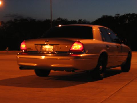 2000 Ford Crown Victoria - Rear view of a gold sedan at night, identified as a 2000 Ford Crown Victoria.