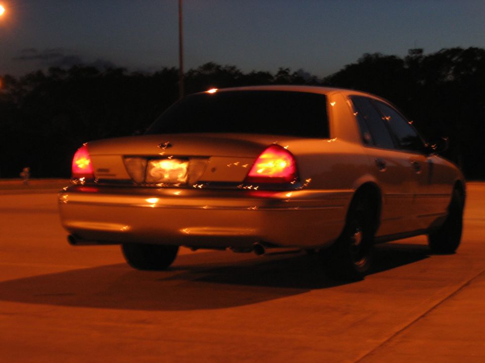 Gold sedan's rear view at night. 2000 Ford Crown Victoria