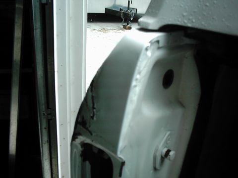 1978 Ford Bronco - Detail of damaged door jamb on a vehicle.