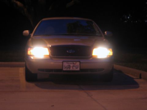 2000 Ford Crown Victoria - This Ford Crown Victoria is seen at night with its headlights illuminated.