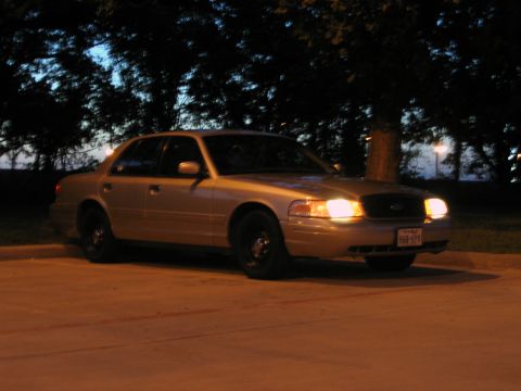 2000 Ford Crown Victoria - A tan 2000 Ford Crown Victoria is seen from a 3/4 front view at night.