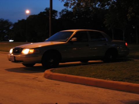 2000 Ford Crown Victoria - A gold 2000 Ford Crown Victoria is parked at night with its headlights illuminated.