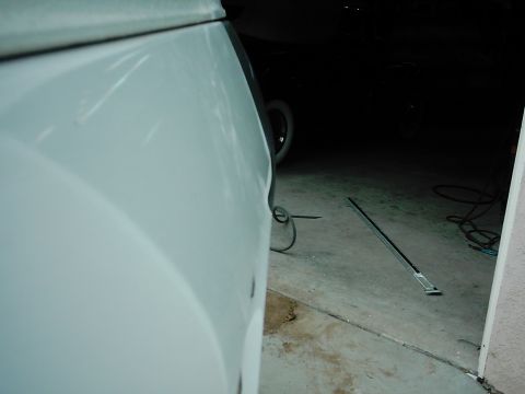1978 Ford Bronco - Detail of a white vehicle panel, with garage interior and floor trim visible.