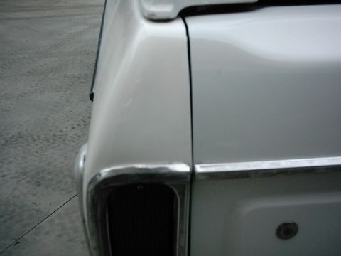 1978 Ford Bronco - Rear quarter panel of a white 1978 Ford Bronco shows damage near the taillight assembly.