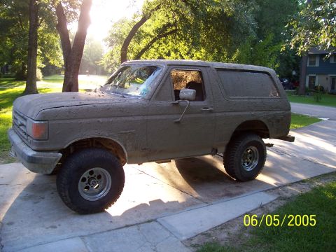 1987 Ford Bronco - This 1987 Ford Bronco is covered in mud, suggesting recent off-road use.