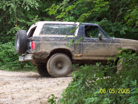1987 Ford Bronco - 1987 Ford Bronco covered in mud while driving off-road.