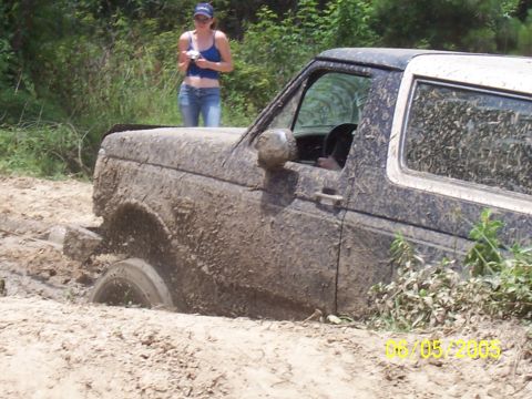 1987 Ford Bronco - This 1987 Ford Bronco is deeply stuck in the mud, with only its front end and driver's side visible.