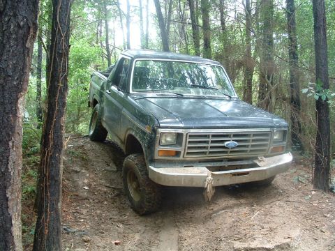 1993 Ford Bronco - This Ford F-Series truck navigates a muddy, wooded trail.