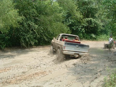 1993 Ford Bronco - This Chevrolet pickup truck is navigating a muddy trail with several passengers.