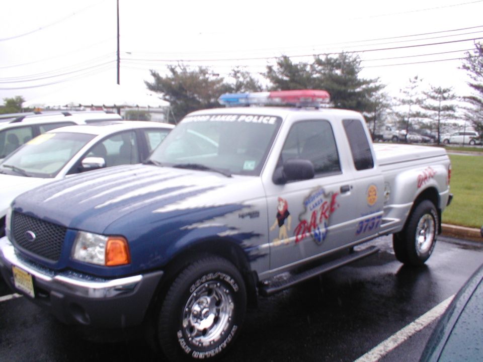 Silver Ford Ranger pickup truck with blue hood, marked "LAKES POLICE DARE" and "3737"