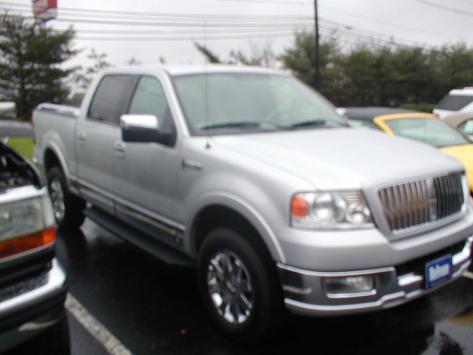 Silver pickup truck front quarter view with chrome grille and wheels