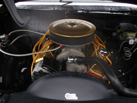 1979 Ford Bronco - Engine bay detail a gold air cleaner and gold valve covers, with visible "CAUTION FAN" text.