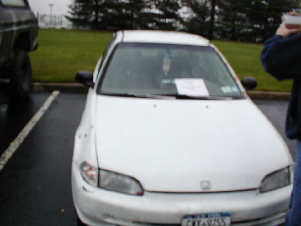 White Honda Civic front view with paper on dashboard