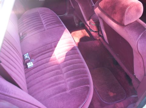 1991 Ford LTD Crown Victoria - Interior view of a car's back seat and floor, plush purple velour upholstery.