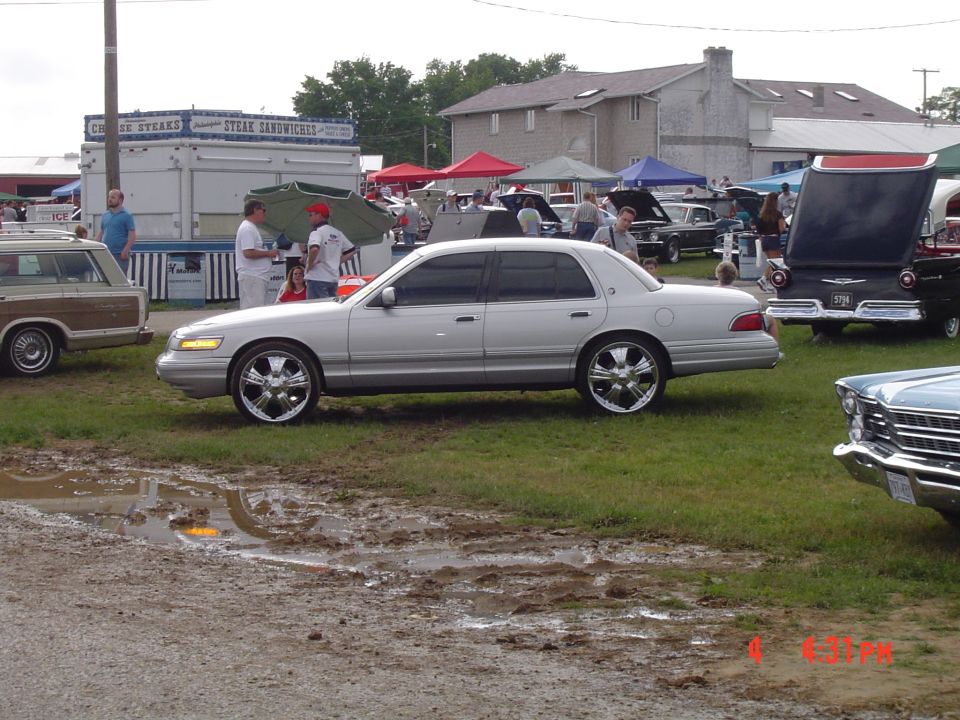 Silver 1999 Ford Crown Victoria sedan, side view, chrome wheels