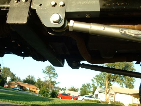 1995 Ford Bronco - Close-up view of the undercarriage suspension system, visible 'CAGE' branding on a component.