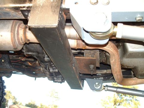 1995 Ford Bronco - A close-up view of a vehicle's undercarriage reveals aftermarket suspension modifications and exhaust components.