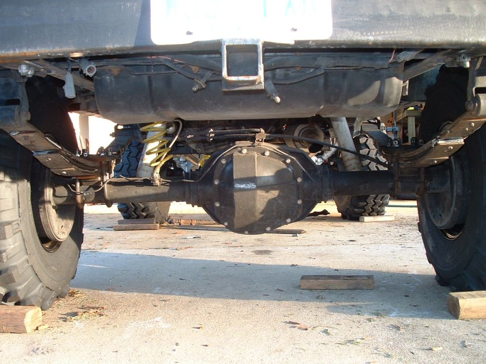 Underside rear view of truck showing solid rear axle, differential and coil springs