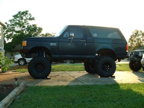 1995 Ford Bronco - This heavily modified Ford Bronco features an extreme lift kit and oversized tires, giving it a commanding presence.