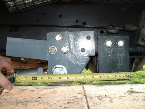 1995 Ford Bronco - A close-up shows a custom suspension component being measured with a yellow tape measure.