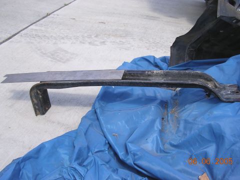 1994 Ford Bronco - A metal bracket, possibly modified, lies on a blue tarp with a concrete background. The date 06.06.2005 is visible.