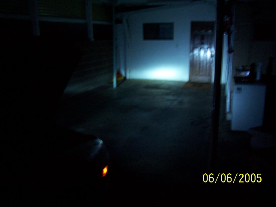 Car headlight illuminated in dark garage