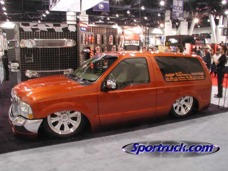 Orange custom two-door Ford SUV at an indoor trade show booth
