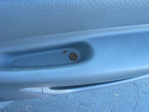 1995 Ford Bronco - A rusty screw is visible on the interior door panel of a vehicle.