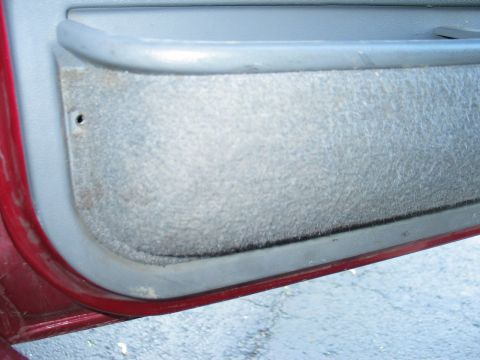 1995 Ford Bronco - Interior view of a car door panel, showing the fabric insert and handle.