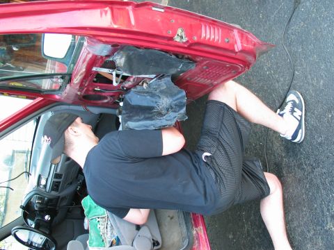 1995 Ford Bronco - A man works on the window motor inside the door panel of a 1995 Ford Bronco.