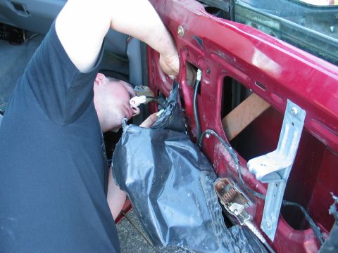 1995 Ford Bronco - Working on the interior of a vehicle door panel, accessing wiring and mechanisms.
