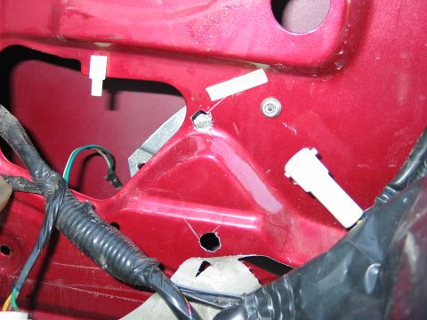 1995 Ford Bronco - Close-up view of a red door's interior panel, showing wiring and mounting points.