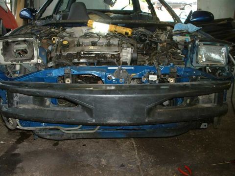 1994 Ford Probe - The front end of a blue 1994 Ford Probe is disassembled, revealing the engine and other components.