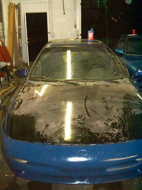 1994 Ford Probe - Front view of a 1994 Ford Probe in a garage, with its hood prepped for paint. Another vehicle is parked behind it.