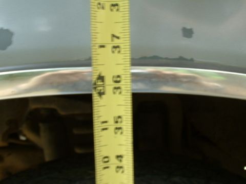 1991 Ford Bronco - A measuring tape is used to gauge height against the vehicle's body panel.