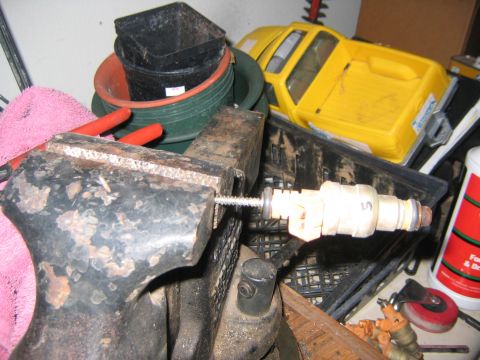 1994 Ford Bronco - A fuel injector is secured in a vise for work, with a toy truck visible in the background.