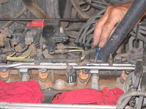 1994 Ford Bronco - Close-up view of engine fuel injectors, with red rags placed below for protection during maintenance.