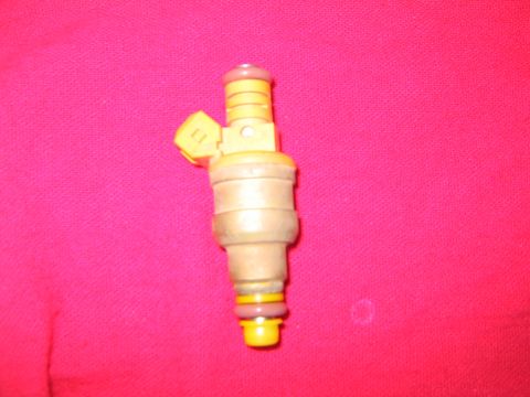 1994 Ford Bronco - A single fuel injector is shown against a pink fabric background.