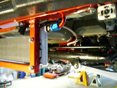 2003 Ford Mustang - The underside of a vehicle features an intercooler, roll cage, and a transmission being worked on.